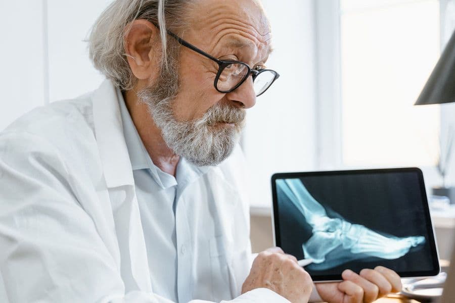 A physiotherapist studying a patient's X-ray on a tablet before the session